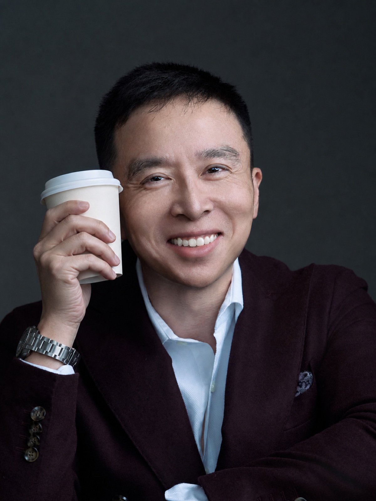 Dr. Aries Tao holding a coffee cup for a friendly consultation